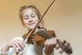 Cute little girl in a beautiful dress playing violin. Joyful and happy emotions. Training. Education. School. Aesthetic training. Royalty Free Stock Photo