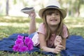 Cute little girl with big blue eyes with a hat lying on a blanket on the grass Royalty Free Stock Photo