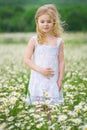 Little girl in camomile meadow