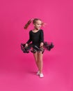 Cute little girl in black dress dancing on pink background Royalty Free Stock Photo