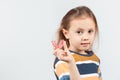 Cute little girl with blond hair is holding a pink dental myofunctional trainer Royalty Free Stock Photo