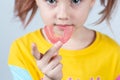 Cute little girl with blond hair is holding a pink dental myofunctional trainer Royalty Free Stock Photo