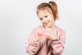 Cute little girl with blond hair is holding a pink dental myofunctional trainer Royalty Free Stock Photo