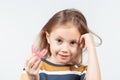 Cute little girl with blond hair is holding a pink dental myofunctional trainer Royalty Free Stock Photo