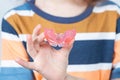 Cute little girl with blond hair is holding a pink dental myofunctional trainer Royalty Free Stock Photo