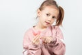 Cute little girl with blond hair is holding a pink dental myofunctional trainer Royalty Free Stock Photo