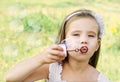 Cute little girl is blowing a soap bubbles