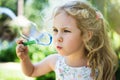 Cute little girl is blowing a soap bubbles and having fun Royalty Free Stock Photo