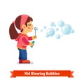 Cute little girl blowing soap bubbles through wand Royalty Free Stock Photo