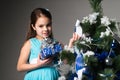 Cute little girl in a blue dress holds a gift Royalty Free Stock Photo