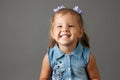 Cute little girl in blue dress smiling and showing her teeth Royalty Free Stock Photo
