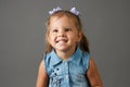 Cute little girl in blue dress smiling and showing her teeth Royalty Free Stock Photo