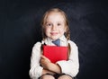 Cute little girl with book. Happy Child on empty blackboard