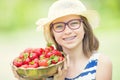 Cute little girl with bowl full of fresh strawberries. Pre - teen girl with glasses and teeth - dental braces Royalty Free Stock Photo