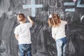 Cute little girl and boy drawing with crayon color on the wall. Works of child. Cute pupil writing on chalkboard Royalty Free Stock Photo