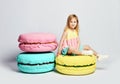 Cute little girl in bright clothes have fun at the birthday party fun room decoration candy macarons