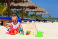 Cute little girl building sandcastle on summer