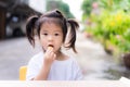 Cute little girl bunches hair and eating oranges into her mouth. Royalty Free Stock Photo