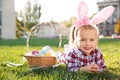 Cute little girl with bunny ears and basket of Easter eggs