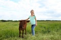 Cute little girl with calf in green field Royalty Free Stock Photo