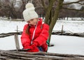 Cute little girl in a cap and jacket smiles