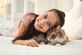 Cute little girl with cat lying on bed. First pet