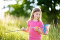 Cute little girl catching butterflies and bugs with her scoop-net Royalty Free Stock Photo