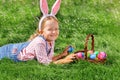 Cute little girl child with basket on green grass in the park. Easter Egg Hunting Concept