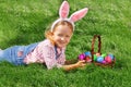 Cute little girl child with basket on green grass in the park. Easter Egg Hunting Concept