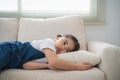 Cute little girl child sleeping on couch sofa with soft pillows at living room at home. Baby girl lying on the sofa couch bed Royalty Free Stock Photo