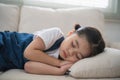 Cute little girl child sleeping on couch sofa with soft pillows at living room at home. Baby girl lying on the sofa couch bed Royalty Free Stock Photo