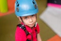 Cute little girl climber in blue protective helmet and gear for climbing standing in climber centre amusement park for children Royalty Free Stock Photo