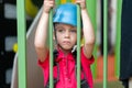 Cute little girl climber in blue protective helmet and gear for climbing standing in climber centre amusement park for children Royalty Free Stock Photo