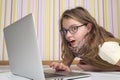 Cute little girl at the computer lying on the floor.