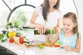 Cute little girl cooking with her mother, healthy food