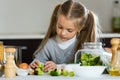 Cute little girl cooking veggies in kitchen