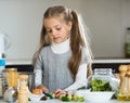 Cute little girl cooking veggies in kitchen