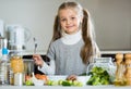 Cute little girl cooking veggies in kitchen