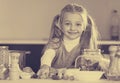 Cute little girl cooking veggies in kitchen