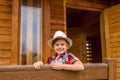 Cute little girl in a cowboy hat,dressed in a denim shorts and red white shirt Royalty Free Stock Photo