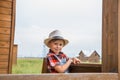 Cute little girl in a cowboy hat,dressed in a denim shorts and red white shirt Royalty Free Stock Photo