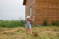 Cute little girl in a cowboy hat,standing in front of a wooden house Royalty Free Stock Photo