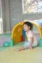 Cute little girl crawling on floor in play ground in gym class. Royalty Free Stock Photo