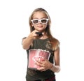 Cute little girl with cup of popcorn switching channels on white background Royalty Free Stock Photo