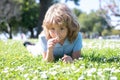 Cute little girl on the daisy flowers meadow in spring day. Happy childhood. Boy lying on grass. Cute kid child enjoying Royalty Free Stock Photo