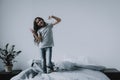 Cute Little Girl Dancing on Bed with Smartphone Royalty Free Stock Photo