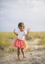 Cute little girl dancing on sandy hill on summer beach Royalty Free Stock Photo