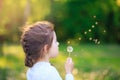 Cute little girl with dandelion flower is smiling in spring park. Happy cute kid having fun outdoors at sunset Royalty Free Stock Photo