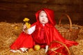 Cute little girl with dandelions wearing in red clothing resting Royalty Free Stock Photo