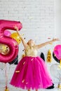 Cute little girl with dark hair, in a beautiful holiday dress and pink balloons for her birthday. The child is 5 years old. Throws Royalty Free Stock Photo